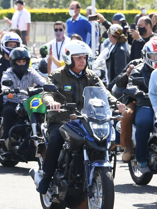 Presiden Brasil Jair Bolsonaro memimpin konvoi ratusan pengendara motor saat melakukan tur di Brasilia, di tengah COVID-19, Minggu (9/5/2021). Bolsonaro melakukan perjalanan dari istana presiden di Brasilia selama satu jam mengelilingi ibu kota Brasil untuk memperingati Hari Ibu. (EVARISTO SA/AFP)