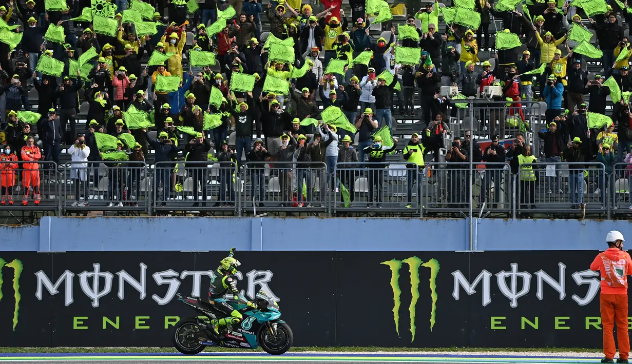 Pembalap Yamaha-SRT Italia Valentino Rossi melewati tribun penonton yang memakai warna kuning pada balapan MotoGP Emilia Romagna di sirkuit Misano, Minggu (24/10/2021). Musim ini merupakan kiprah terakhir Rossi melaju di lintasan MotoGP setelah bertarung lebih dari 20 tahun. (ANDREAS SOLARO / AFP)