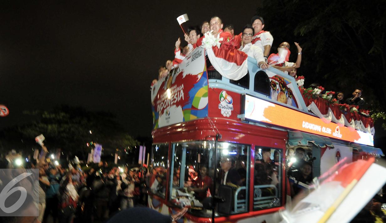 Arak-arakan atlet peraih medali Olimpiade Rio 2016 disambut meriah oleh warga, Senayan, Jakarta, Selasa (23/8). Setibanya di Tanah Air, atlet Olimpiade diarak menggunakan bus Bamdros menuju gedung Kemenpora. (Liputan6.com/Yoppy Renato)
