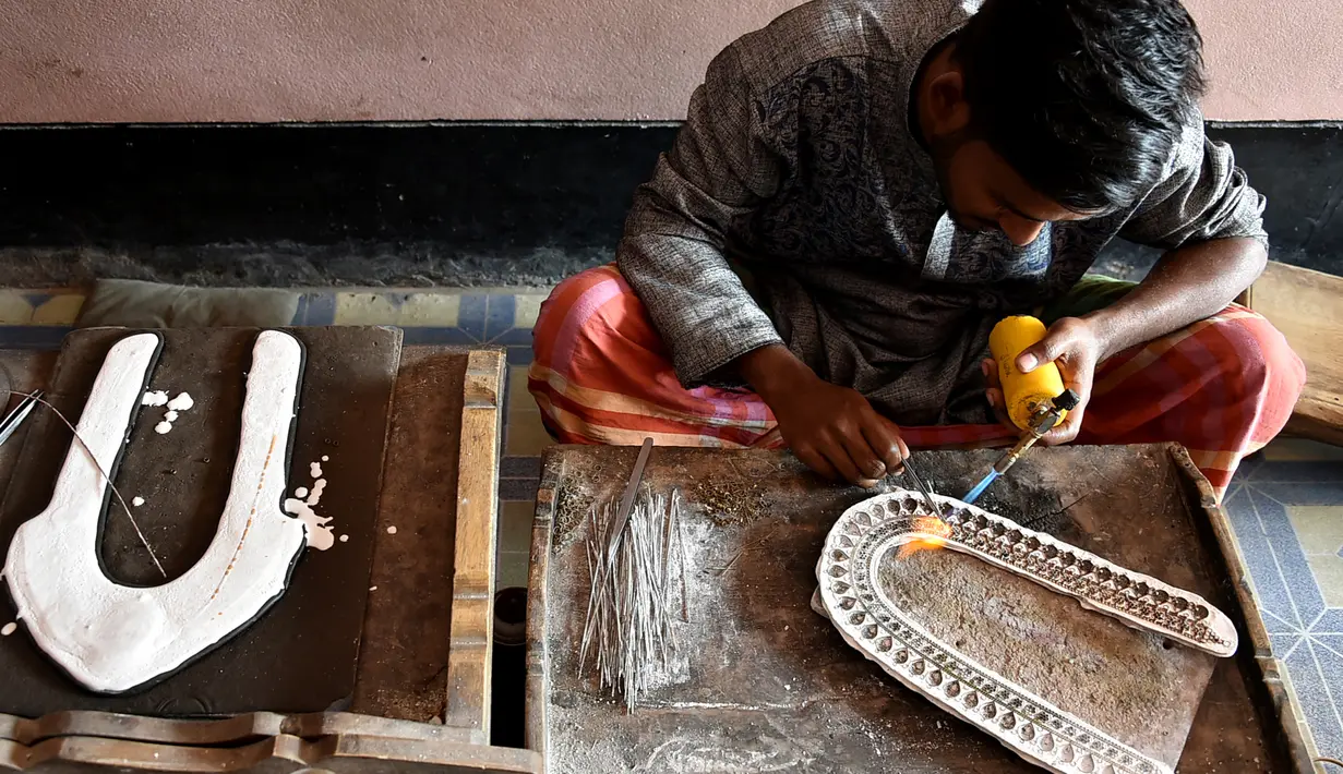 Perajin membuat perhiasan dengan obor las di bengkelnya di Vakurta, pinggiran Dhaka, Bangladesh, 10 Februari 2020. Desa tersebut, yang berjarak 30 menit berkendara dari Dhaka, merupakan pusat para artisan dan perajin perhiasan tradisional Bangladesh. (Xinhua/Stringer)