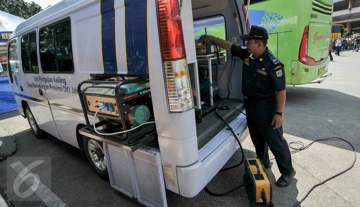 Petugas melakukan uji emisi bus yang akan digunakan untuk armada Lebaran di Terminal Kampung Rambutan, Jakarta, Jumat (24/6). Dishub DKI melakukan tes kesehatan pengemudi dan pengecekan bus jelang arus mudik 2016. (Liputan6.com/Yoppy Renato)