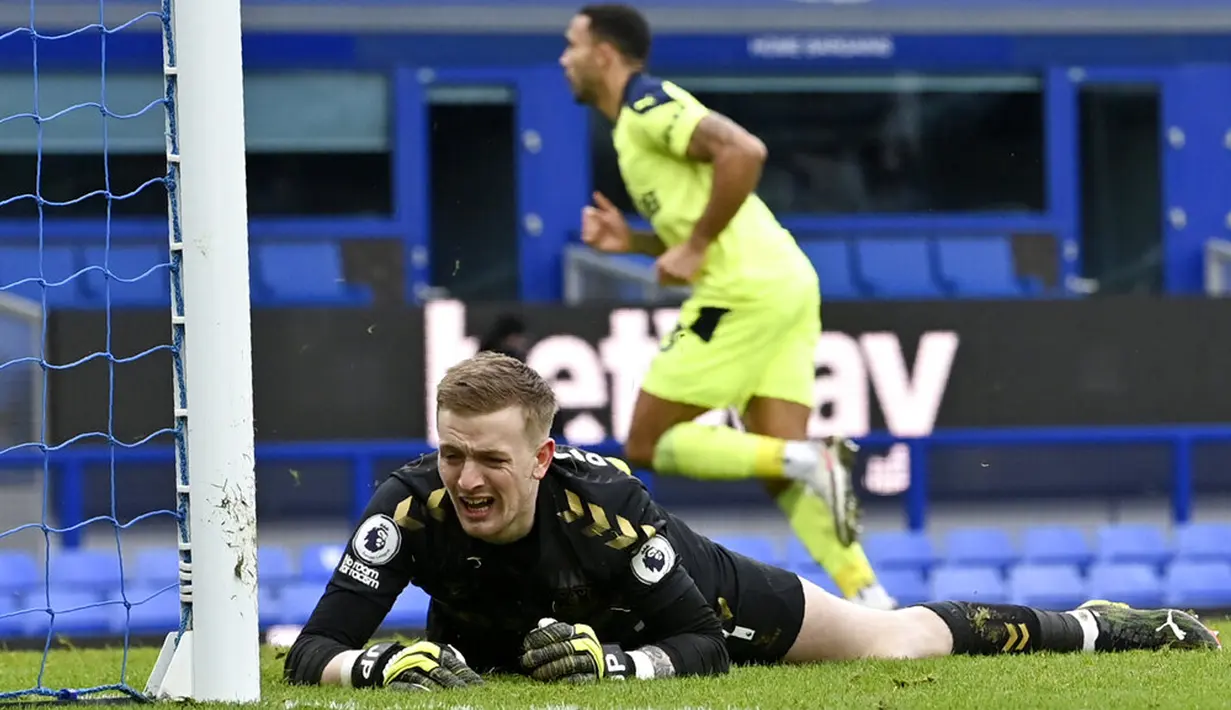 Kiper Everton Jordan Pickford (depan) bereaksi setelah pemain Newcastle United Callum Wilson (belakang) mencetak gol ke gawangnya pada pertandingan Liga Inggris di Goodison Park, Liverpool, Inggris, Sabtu (30/1/2021). Newcastle United menang 2-0. (Paul Ellis/Pool via AP)