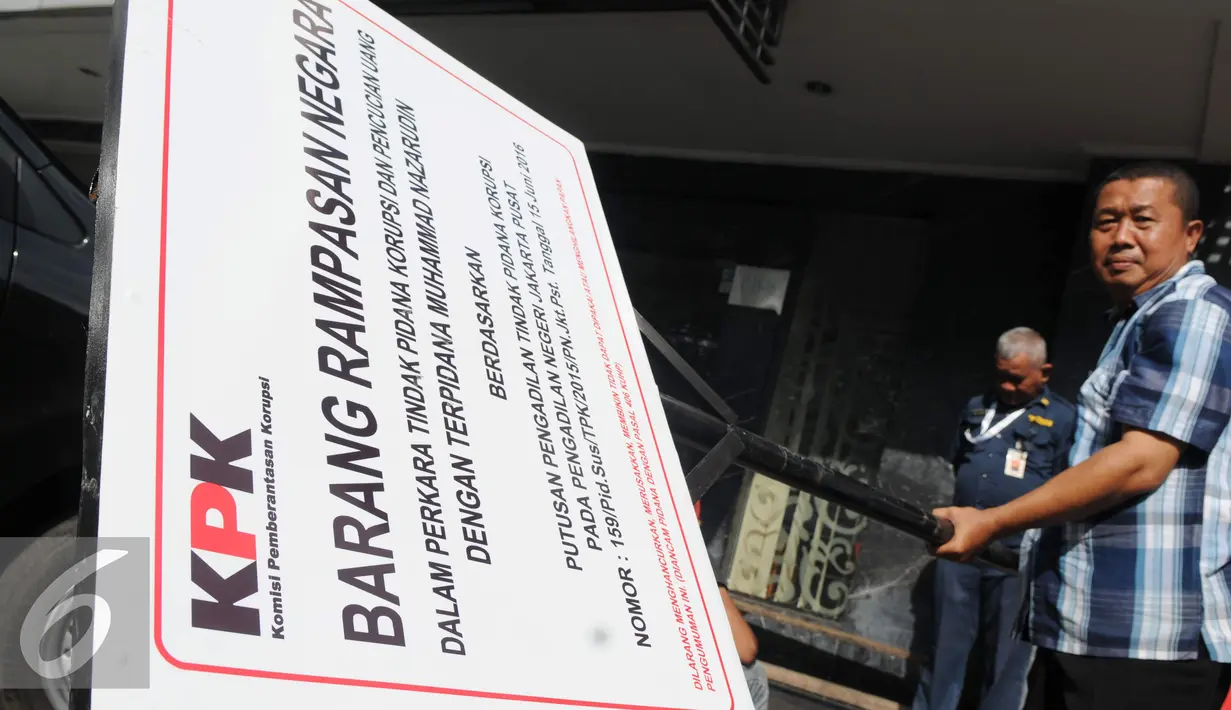 Pekerja memegang plang segel ruko Nazaruddin sebelum ditancapkan di Wijaya Grand Center, Jakarta Selatan, Senin (28/11). Ruko tersebut masuk dalam daftar kekayaan Nazaruddin yang dirampas negara. (Liputan6.com/Helmi Affandi)