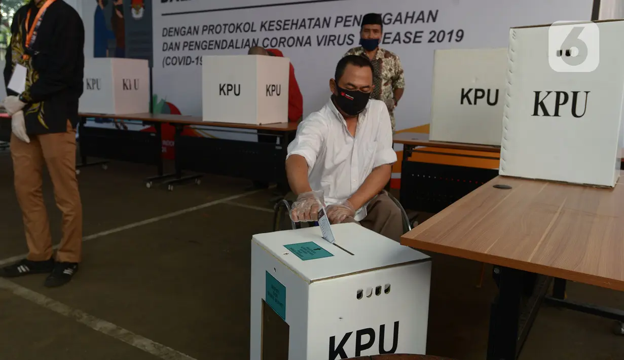 Petugas memasukan surat pemungutan suara dalam pemilihan serentak 2020 saat simulasi di Halam Kantor KPU, Jakarta, Rabu (22/7/2020). Simulasi pemungutan suara di TPS dengan menerapkan protokol kesehatan Covid-19. (merdeka.com/Imam Buhori)