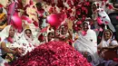 Para janda India melemparkan kelopak bunga saat menghadiri festival holi di kota Vrindavan, India, (9/3). Holi merupakan festival awal musim semi yang ditandai dengan aksi melempar bubuk berwarna-warni. (AFP Photo / Dominique Faget)