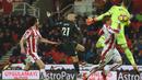 Sepakan David Silva (tengah) melewati adangan kiper Stoke City, Jack Butland pada lanjutan Premier League di Bet 365 Stadium, Stoke, (13/3/2018). Manchester City menang 2-0. (AFP/Paul Ellis)