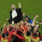 Pemain Maroko merayakan kemenangan timnya atas Spanyol dengan cara melemparkan pelatih kepala Walid Regragui saat babak 16 besar Piala Dunia 2022 yang berlangsung di Education City Stadium, Selasa (06/12/2022). (AP/Abbie Parr)