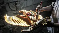 Perajin menyelesaikan pembuatan patung Garuda Pancasila di industri rumahan kawasan Bali Raya, Kalimalang, Jakarta Timur, Selasa (1/7/2021). Usaha ini kembali bangkit di masa pandemi Covid-19 seiring datangnya pesanan dari sejumlah wilayah di Indonesia. (merdeka.com/Iqbal S. Nugroho)