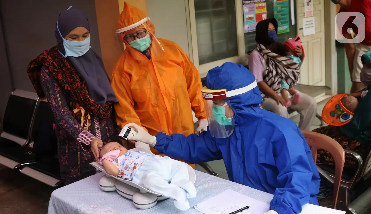 Bidan mengenakan alat pelindung diri (APD) saat melakukan imunisasi kepada bayi di Puskesmas Karawaci Baru, Tangerang, Banten, Rabu (13/5/2020). Pelayanan imunisai sesuai jadwal ini diberikan kepada bayi untuk menambah kekebalan imun tubuh. (Liputan6.com/Angga Yuniar)