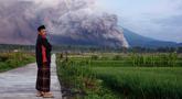 Seorang pria melihat saat Gunung Semeru mengeluarkan material vulkanik saat meletus, Lumajang, Jawa Timur, Indonesia, Minggu (4/12/2022). Gunung Semeru erupsi pada dini hari tadi sekitar pukul 02.46 WIB. (AP Photo)