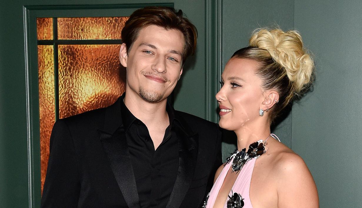 <p>Millie Bobby Brown (kanan) dan pacarnya Jake Bongiovi menghadiri pemutaran perdana film Enola Holmes 2 di The Paris Theatre, New York, Amerika Serikat, 27 Oktober 2022. Brown tertangkap kamera menatap penuh kasih pada putra rocker Jon Bon Jovi itu saat mereka berpose untuk fotografer. (Photo by Evan Agostini/Invision/AP)</p>