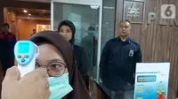 Petugas mengecek suhu pegawai atau tamu yang akan masuk di lingkungan kantor PLN Jakarta, Kamis (05/3/2020). PLN melakukan langkah preventif terhadap upaya pencegahan penyebaran virus corona dari level manajemen direksi hingga level pegawai. (Liputan6.com/Pool/PLN)