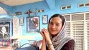 Selanjutnya, Beby mengenakan atasan knit coklat dipadukan kerudung abu-abu bercorak sambil membawa tas Loro Piana di sampingnya. [@bebytsabina]
