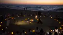 Wanita mengambil bagian dalam upacara Tashlich, di mana mereka menuliskan hal-hal yang ingin mereka lepaskan sebelum melemparkannya ke dalam api, di pantai di Tel Aviv, Israel (14/9/2021). (AP Photo/Maya Alleruzzo)