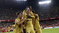 Penyerang Barcelona, Robert Lewandowski (tengah) berselebrasi dengan rekan satu timnya setelah mencetak gol ke gawang Sevilla pada pertandingan lanjutan La Liga Spanyol di Seville, Spanyol, Sabtu (3/9/2022). Barcelona menang telak atas Sevilla 3-0. (AP Photo/Jose Breton)