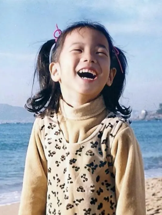 Senyuman cerah Jisoo ternyata sudah tampak sejak dia kecil. Mengenakan busana berwarna earth tone, Jisoo tampil dengan rambut di kuncir dua dan berpose di pinggir pantai. (Foto: Instagram/ roses_are_rosie)