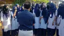 Sejumlah siswi berbicara dengan kepala sekolah mereka di luar kampus di Udupi, India, Jumat, 4 Februari 2022. Sejumlah sekolah di negara bagian Karnataka di India melarang para siswi memakai hijab di dalam kelas. (Bangalore News Photos via AP)