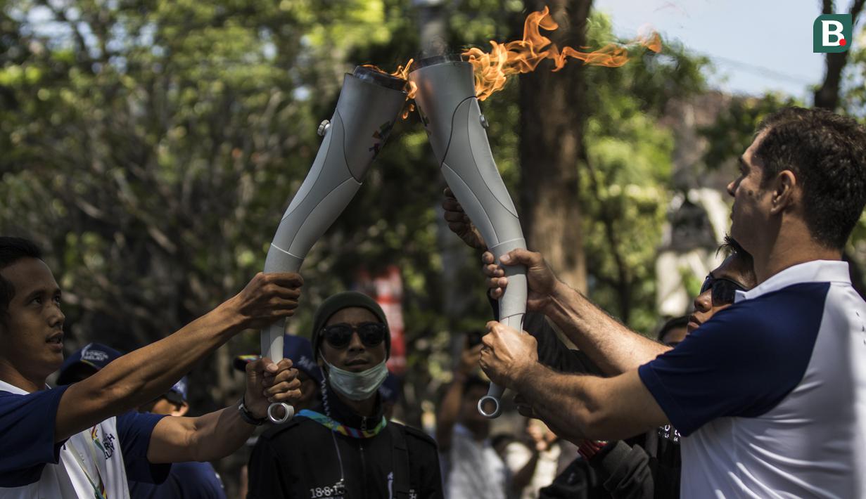 Pevoli legendaris Indonesia, Pascal Wilmar, menerima obor Asian Games XVIII saat pawai di Denpasar, Bali, Selasa (24/7/2018). Sebanyak 53 kota di Indonesia akan dilalui oleh obor Asian Games. (Bola.com/Vitalis Yogi Trisna)