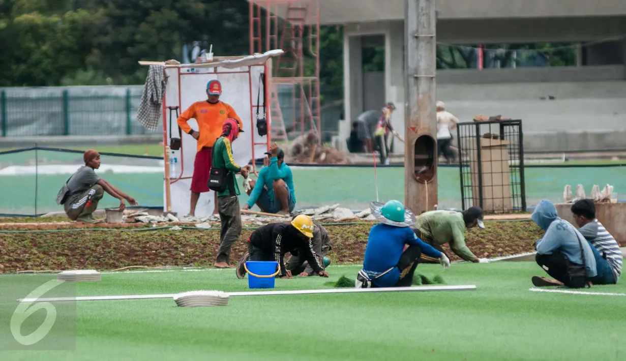 Pekerja menyelesaikan renovasi lapangan latihan timnas Indonesia di Kompleks Gelora Bung Karno, Senayan, Jakarta, Rabu (10/5). Pemerintah melakukan renovasi total kawasan Gelora Bung Karno guna menyambut Asian Games 2018. (Liputan6.com/Gempur M Surya)
