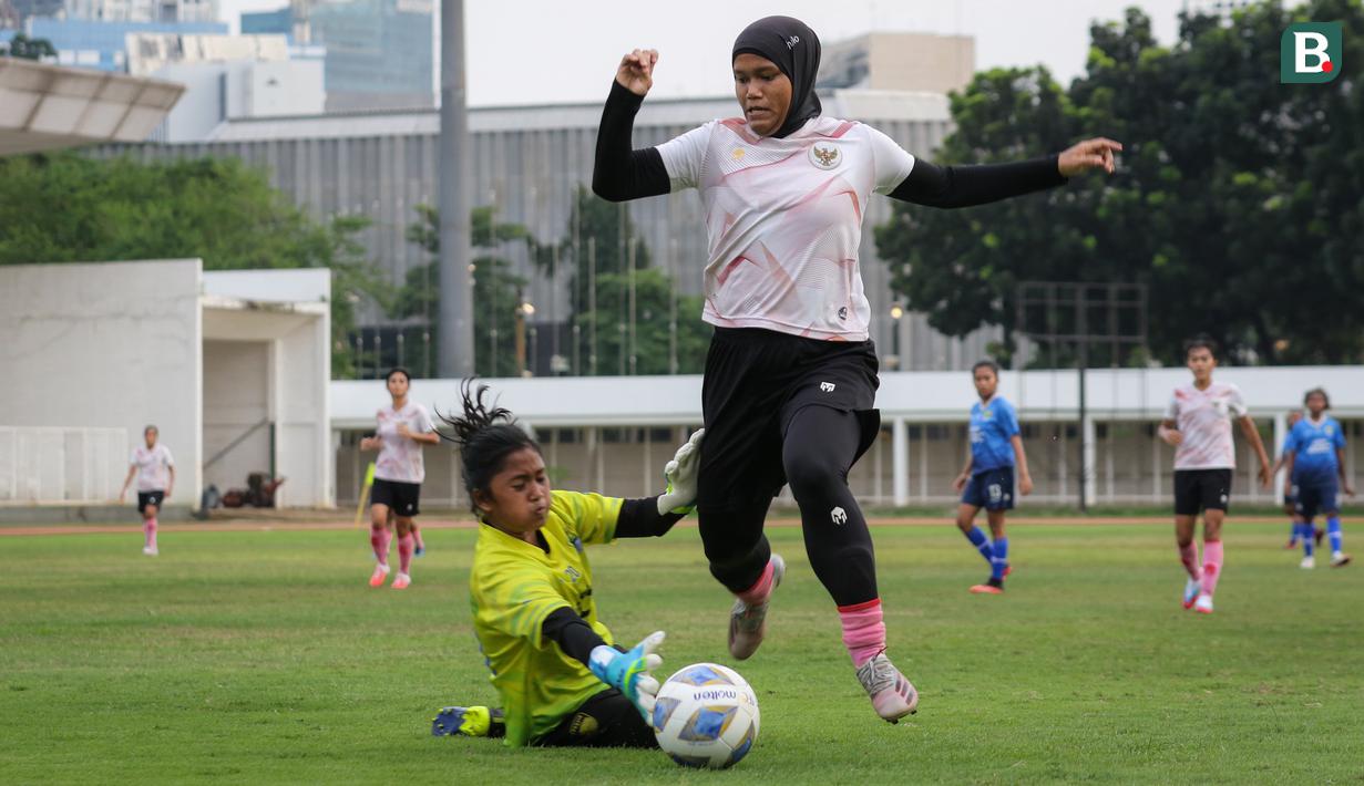Pemain Timnas Wanita Indonesia, Insyafadya Salsabillah (kiri) berusaha melewati kiper Tim Putri Persib Bandung saat pertandingan uji coba di Stadion Madya, Jakarta, Kamis (13/01/2022). Laga yang dimenangkan Garuda Pertiwi dihadiri oleh Ketua Umum PSSI, Mochamad Iriawan.(Bola.com/Bagaskara Lazuardi)