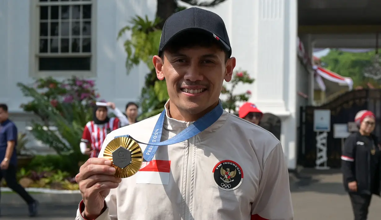 Peraih medali emas cabang olahraga panjat tebing putra Olimpiade Paris 2024, Veddriq Leonardo berfoto dengan medali yang diraihnya di Istana Merdeka, Jakarta, pada Kamis 15 Agustus 2024. (BAY ISMOYO/AFP)