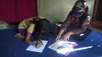 Seorang guru di Mamasa ketika mengunjungi rumah siswanya untuk ujian semester (Liputan6.com/Abdul Rajab Umar)