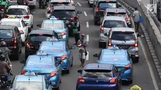 Pedagang asongan menjajakan barang dagangannya di persimpangan lampu merah di Jakarta, Jumat (22/2). Keahlian yang terbatas menyebabkan sebagian orang harus bekerja di tengah padatnya kendaraan Ibukota. (Liputan6.com/Immanuel Antonius)