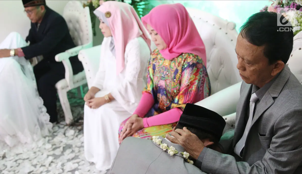 Komedian Caisar Aditya Putra dan Intan Sri Mardiani melangsungkan prosesi sungkeman kepada orangtua usai ijab kabul pernikahan di kawasan Cimahpar, Bogor, Jawa Barat, Sabtu (30/6). (Liputan6.com/Herman Zakharia)