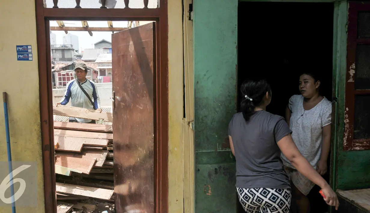 Warga bukit Duri berbincang di rumah yang sebagian telah dibongkar oleh Pemprov DKI Jakarta, Selasa (13/9). Pemprov DKI berencana keluarkan Surat Peringatan (SP) 3 hari ini yang dilanjutkan pembongkaran pada Rabu 14/9 besok. (Liputan6.com/Yoppy Renato)