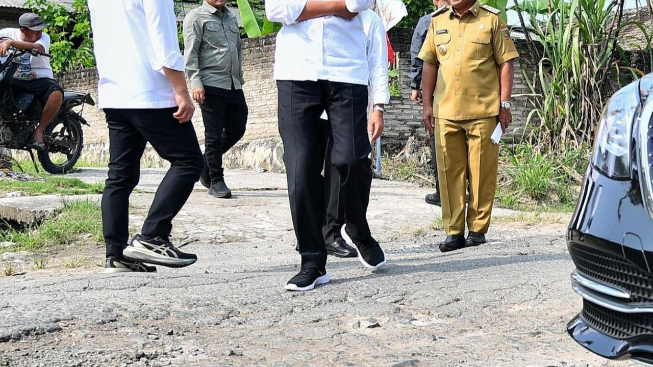 Jokowi kemudian turun dari mobil kepresidenan dan mengecek langsung jalan rusak yang dilewatinya.&nbsp;Foto: BPMI Setpres/Vico
