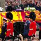 Band Coldstream Guards tampil saat prosesi Ratu Elizabeth II di London, Inggris, 14 September 2022. Warga berada di kanan-kiri jalan untuk menyaksikan keberangkatan peti jenazah Ratu Elizabeth II dari Istana Buckingham yang telah menjadi rumahnya sebagai ratu selama 70 tahun terakhir. (Nathan Denette/The Canadian Press via AP)