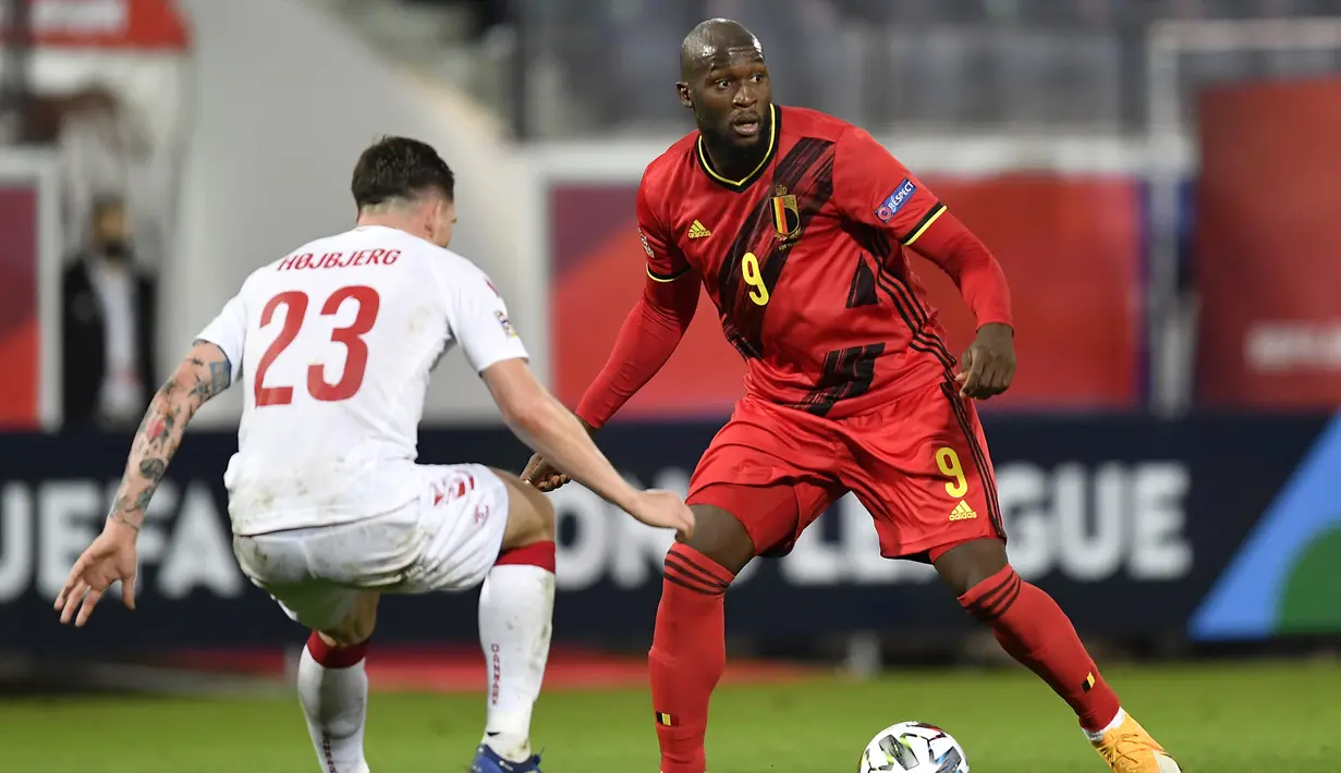 Penyerang Belgia, Romelu Lukaku, berebut bola dengan gelandang Denmark, Pierre Hojbjerg, pada laga lanjutan UEFA Nations League di Stadion Den Dreef, Kamis (19/11/2020) dini hari WIB. Belgia menang 4-2 atas Denmark. (AFP/John Thys)