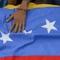 Bendera negara Venezuela yang bawa saat mengiringi pemakaman Jose Francisco Guerrero di San Cristobal, Tachira State, Venezuela (19/5). Jose tewas akibat tembakan saat ia terjebak dalam konfrontasi antara demonstran dan polisi setempat. (AFP/Luis Robayo)