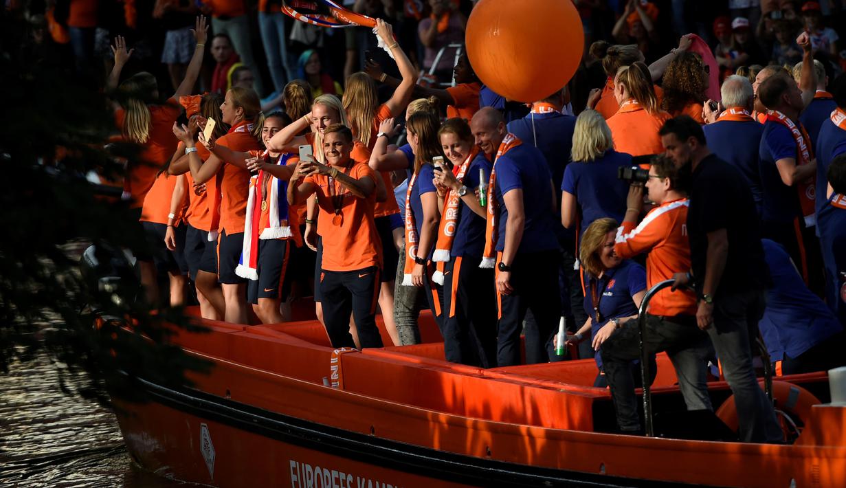 Para pemain timnas putri Belanda mengabadikan momen sambutan suporter dari atas perahu saat parade juara usai meraih trofi Piala Eropa Wanita 2017 di Sungai Utrecht, (7/8/2017). (AFP/John Thys)