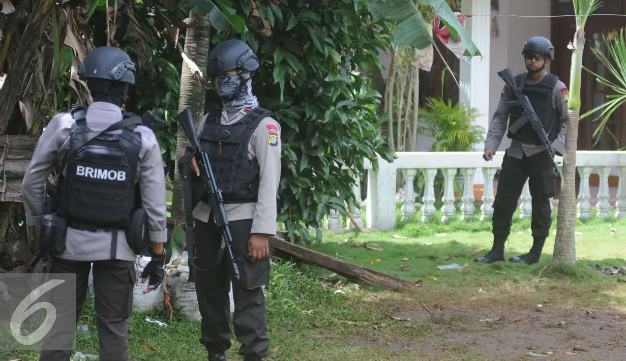 Petugas Kepolisian Brimob Polda Metro Jaya berjaga disekitar area rumah terduga teroris di Setu, Tangerang Selatan, Rabu (21/12). Dalam penggerebekan tersebut terjadi baku tembak hingga menewaskan tiga tersangka. (Liputan6.com/Helmi Affandi)