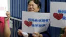 Salah satu keluarga penumpang MH370 menangis saat menggelar aksi di depan kantor Malaysia Airlines, Beijing, China, Kamis (6/8). Pemerintah Malaysia telah resmi menyatakan puing pesawat di Pulau Reunion adalah bagian dari MH370. (REUTERS/Jason Lee)