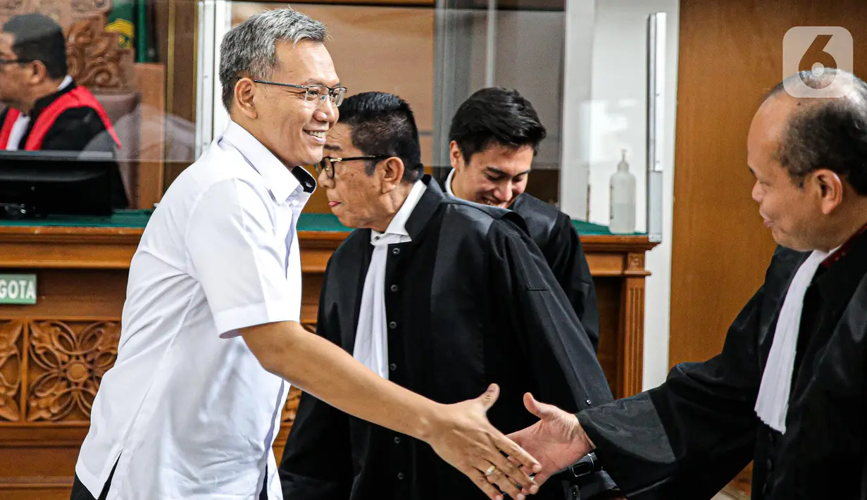 Terdakwa Agus Nurpatria tersenyum saat berjabat tangan dengan kuasa hukum usai menjalani sidang perdana di PN Jakarta Rabu (19/10/2022). Agus Nurpatria menyalami kuasa hukum dengan penuh senyuman usai menjalani sidang dengan agenda pembacaan surat dakwaan kasus obstruction of justice atau perintangan proses penyidikan terkait perkara dugaan pembunuhan berencana terhadap Nofriansyah Yosua Hutabarat atau Brigadir J. (Liputan6.com/Faizal Fanani)