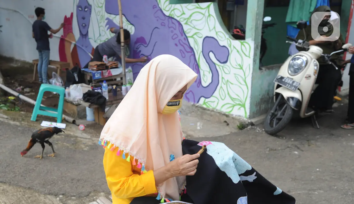 Warga menyelesaikan pembuatan batik tulis saat pelaksanaan kegiatan mural Raincity Strike #8 di Kampung Batik Cibuluh, Bogor, Minggu (22/11/2020). Kegiatan seni mural ini melibatkan puluhan seniman mural se-Jabodetabek di kampung batik. (merdeka.com/Arie Basuki)