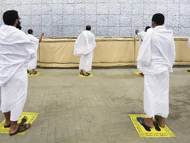 Jemaah haji melangsungkan lontar jumrah dengan menerapkan jaga jarak aman untuk menghindari penularan COVID-19 di Mina, Arab Saudi, Jumat (31/7/2020). Ritual melempar batu ke pilar ini menjadi simbol merajam setan. (Saudi Ministry of Media via AP)