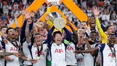 Pemain depan Tottenham Hotspur asal Korea Selatan, Son Heung-min mengangkat trofi Liga Europa saat merayakan kemenangan bersama rekan setimnya usai pertandingan final melawan Manchester United di stadion San Mames, Bilbao, pada 21 Mei 2025 waktu setempat atau Kamis (22/5) dini hari WIB. (Thomas COEX/AFP)