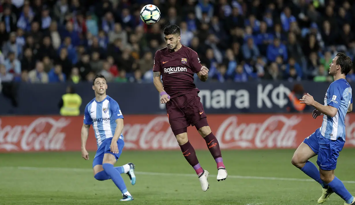 Striker Barcelona, Luis Suarez, menyundul bola saat pertandingan melawan Malaga pada laga La Liga di Stadion La Rosaleda, Sabtu (10/3/2018). Malaga takluk 0-2 dari Barcelona. (AP/M.Pozo)