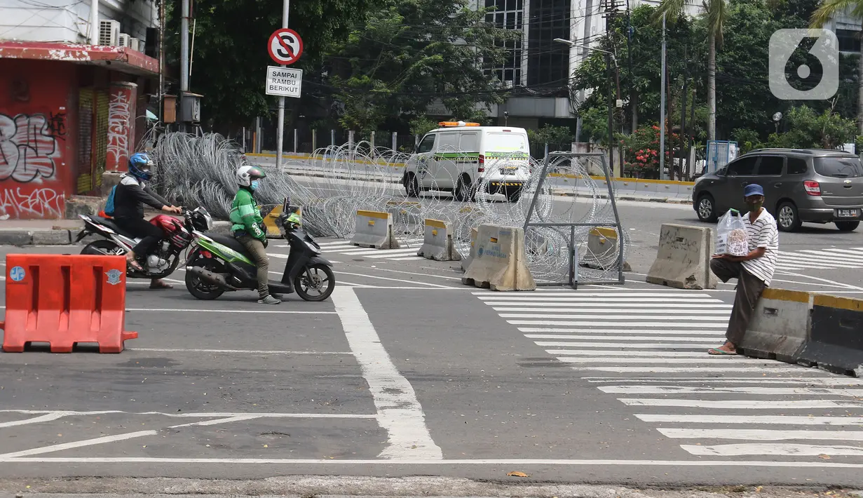 Pihak kepolisian menutup akses jalan di kawasan Harmoni, Jakarta, Sabtu (24/7/2021). Kepolisian menyiapkan kawat berduri di kawasan Harmoni untuk mengantisipasi aksi demonstrasi dengan tuntutan menolak perpanjangan pemberlakuan pembatasan kegiatan masyarakat (PPKM). (Liputan6.com/Herman Zakharia)