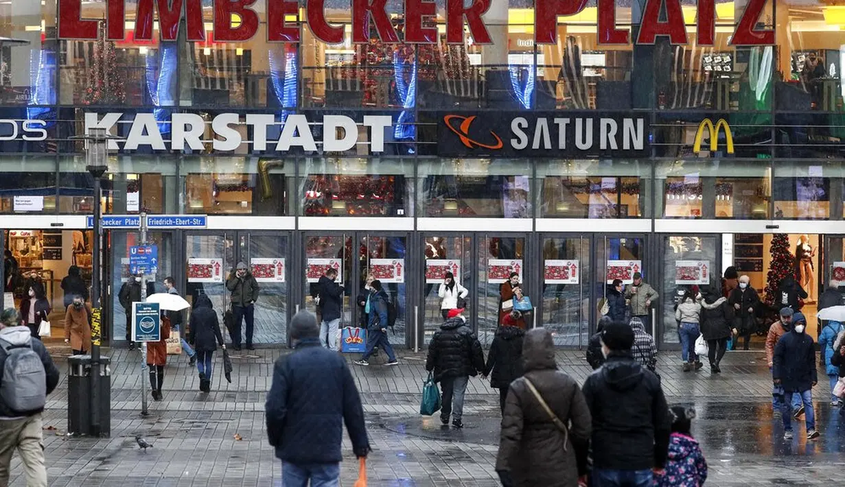 Orang-orang berjalan ke pusat perbelanjaan di pusat Kota Essen, Jerman, Senin (14/12/2020). Jerman melakukan lockdown nasional pada 16 Desember 2020 untuk memerangi pandemi COVID-19. (AP Photo/Martin Meissner)