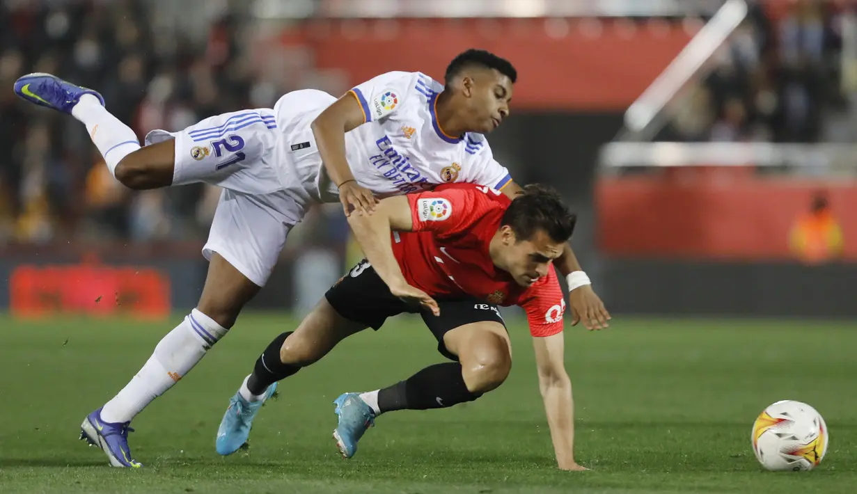 Penyerang Real Madrid, Rodrygo berebut bola dengan pemain Mallorca, Brian Olivan pada pertandingan lanjutan La Liga Spanyol di Palma de Mallorca, Spanyol, Selasa (15/3/2022). Madrid menang telak atas Mallorca 3-0. (AP Photo/Francisco Ubilla)
