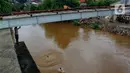 Seorang anak bersiap melompat dari jembatan ke Kali Ciliwung Kalibata, Jakarta, Selasa (25/2/2020). Kali Ciliwung meluap usai hujan deras mengguyur Jakarta dan sekitarnya pada kemarin malam. (merdeka.com/magang/Muhammad Fayyadh)