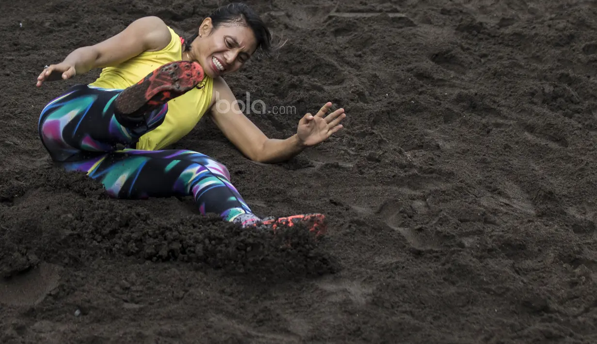 Atlet atletik Indonesia, Maria Londa, melakukan pendaratan saat latihan jelang SEA Games 2017 di Lapangan umum Mengwi, Bali, Minggu (10/7/2017). (Bola.com/Vitalis Yogi Trisna)