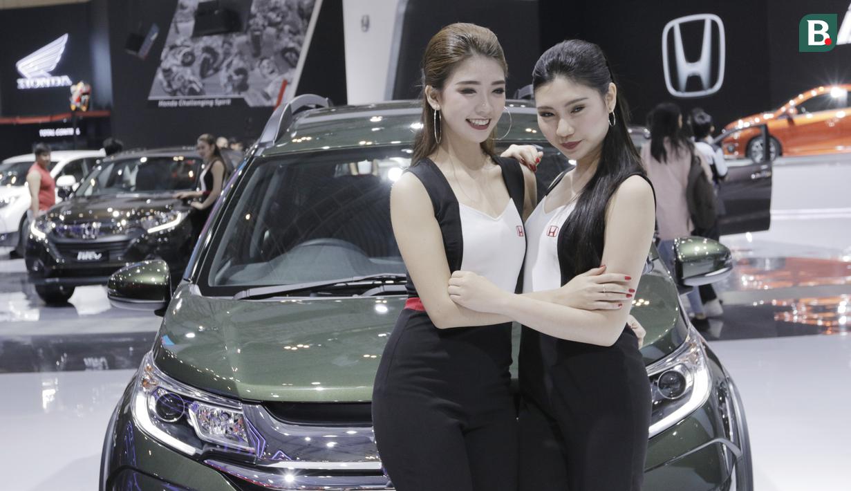 SPG berpose di depan mobil yang dipamerkan pada gelaran GIIAS 2018 di ICE, BSD City, Kamis (2/8/2018). Selain menjadi pemanis dan daya tarik pameran, SPG juga bisa membantu menjabarkan spesifikasi kendaraan yang dipamerkan. (Bola.com/M Iqbal Ichsan)