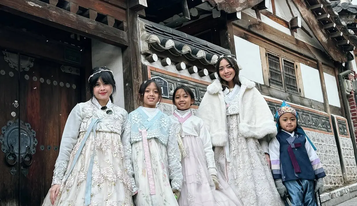 Jalan-jalan di sebuah spot foto menarik dengan latar rumah-rumah zaman dahulu, Ririn dan anak-anak yang tampil kompak mengenakan hanbook ini terlihat keren. Apalagi kedua putri dari Ririn Dwi Ariyanti yang kini sudah tumbuh semakin besar pun terihat menggemaskan. (Liputan6.com/IG/@ririndwiariyanti)