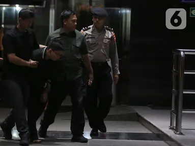 Petugas Komisi Pemberantasan Korupsi (KPK) menggiring orang yang mengaku-aku sebagai pegawai KPK di Gedung Merah Putih KPK, Jakarta, Rabu (5/2/2025). (Liputan6.com/Helmi Fithriansyah)