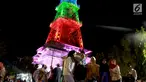Warga berfoto dekat Pakaya Tower di kawasan taman Limboto, Kabupaten Gorontalo, Sabtu (12/1). Pakaya Tower berdiri megah bak Menara Eiffel dengan tata lampu warna-warni. (Liputan6.com/Arfandi Ibrahim)
